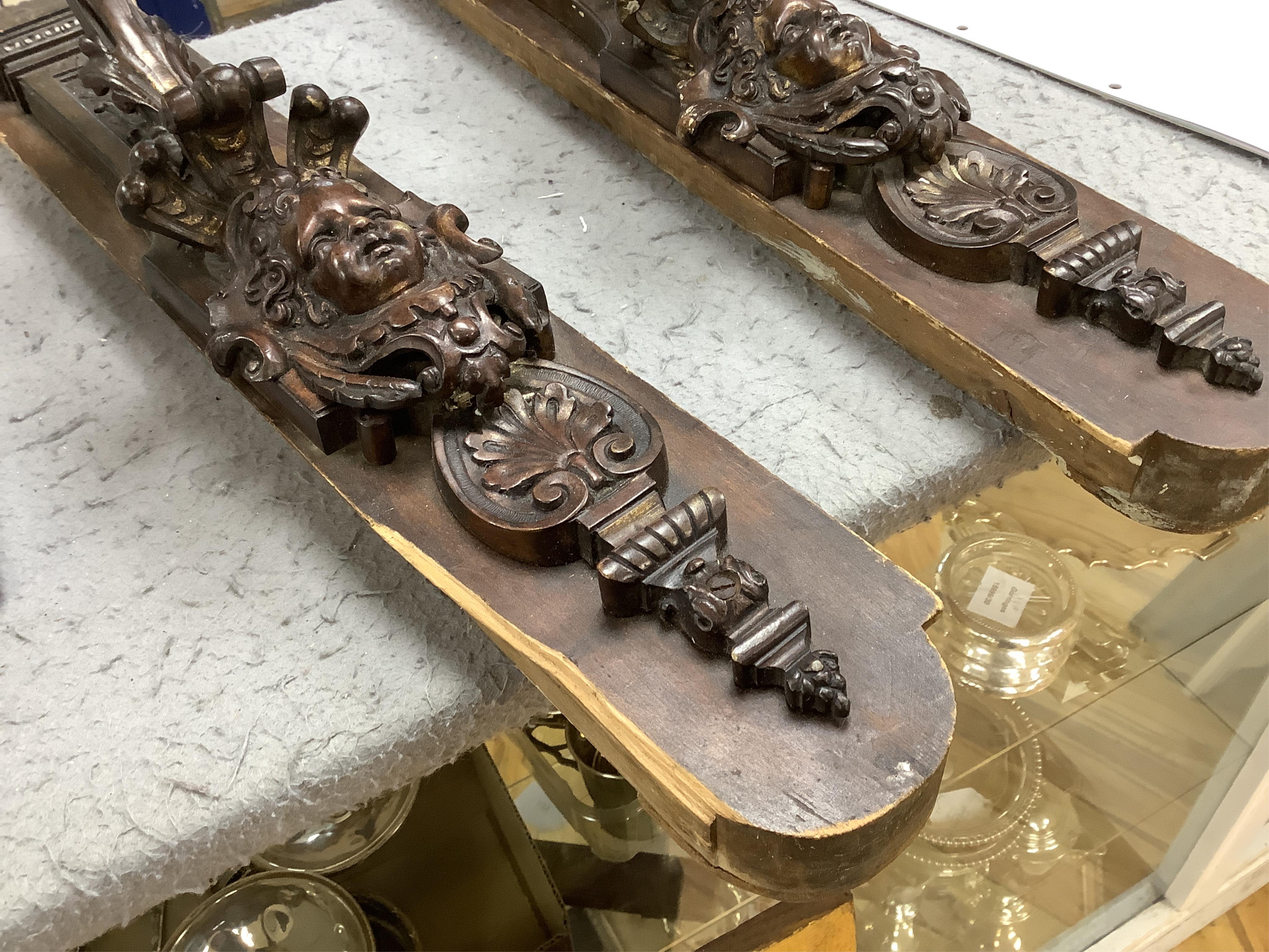 A pair of French bronze wall lights, c.1900 decorated with masks, mounted on wooden plinths, 54cm high. Condition - poor to fair